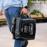 Person carrying Aerolite MiniMAX trolley backpack by handle