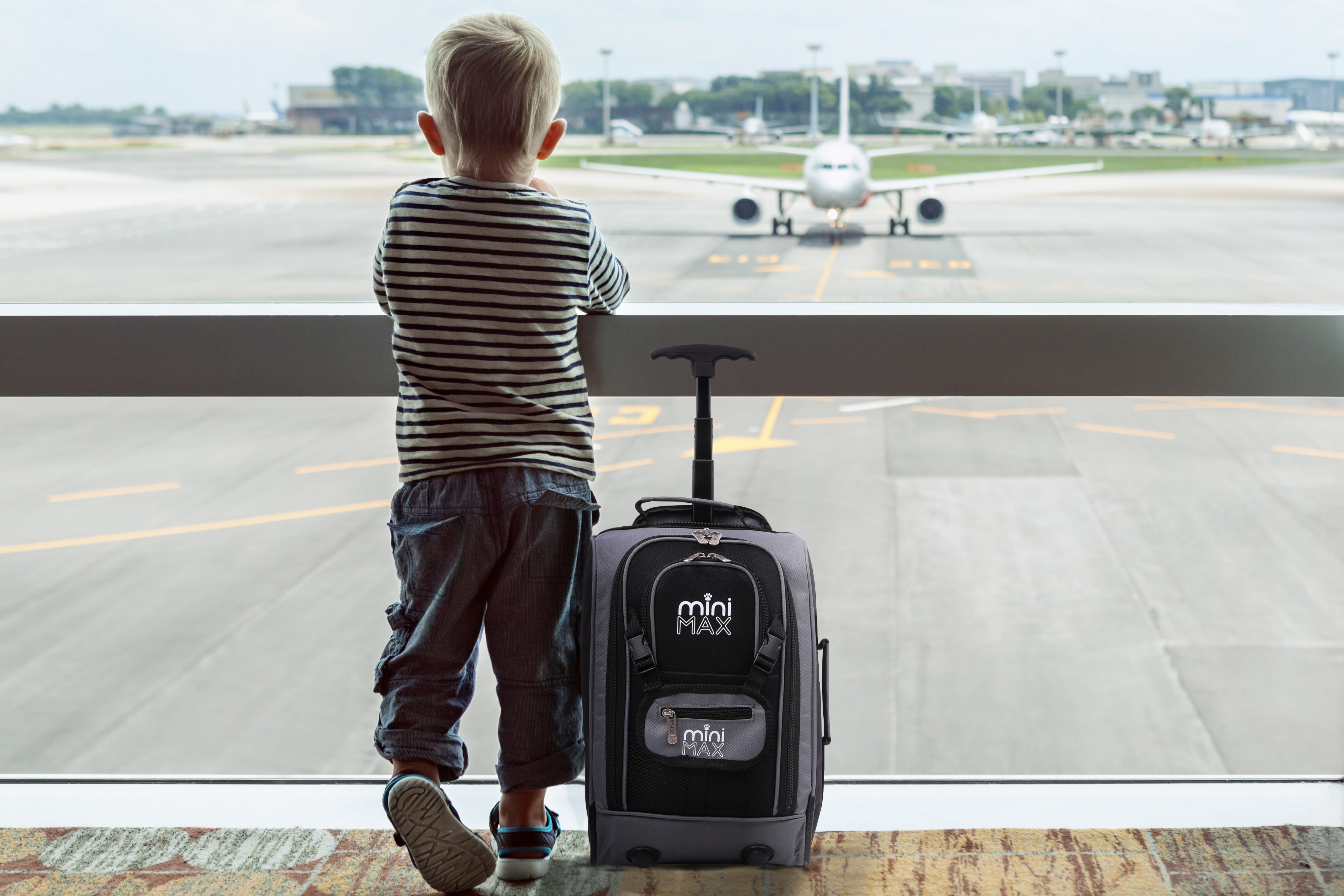 Child with Aerolite MiniMAX trolley backpack at airport window