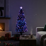 Decorative Christmas tree with blue lights in a cozy living room setting.